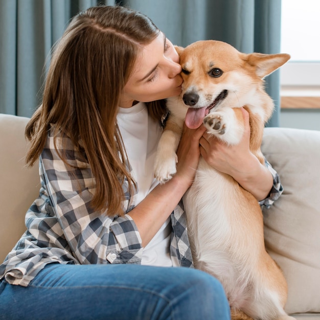 Photo front view of woman on couch kissing dog