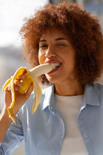 バナナを食べる正面図の女性