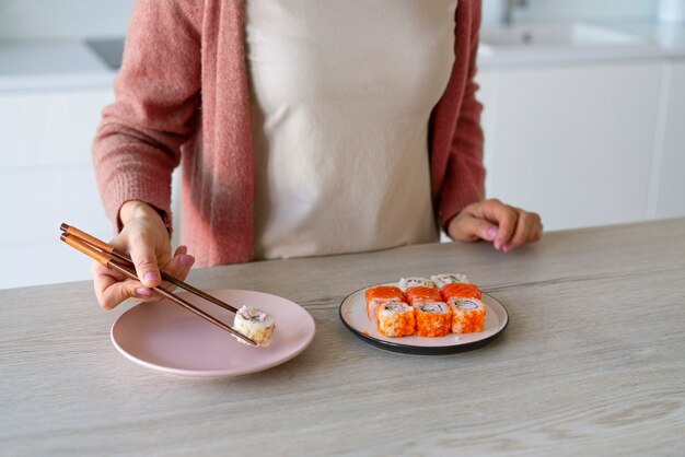 写真 家で寿司を食べる正面図の女性