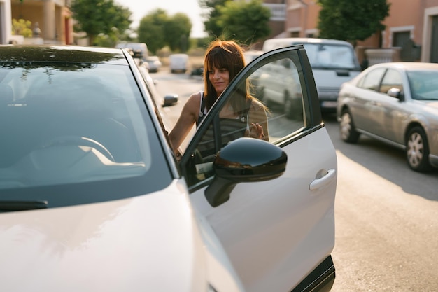 Front view of a woman getting into a car