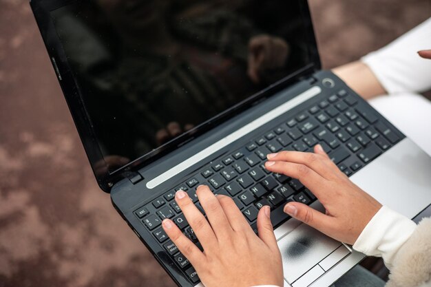 Photo front view woman hands typing laptop