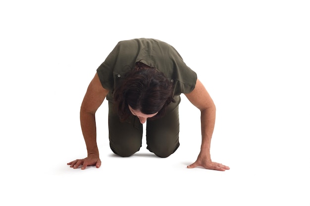 Photo front view of a woman on her knees searching or staring at something on the floor on white background
