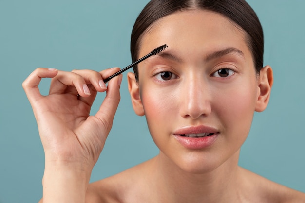 Photo front view woman holding brow brush