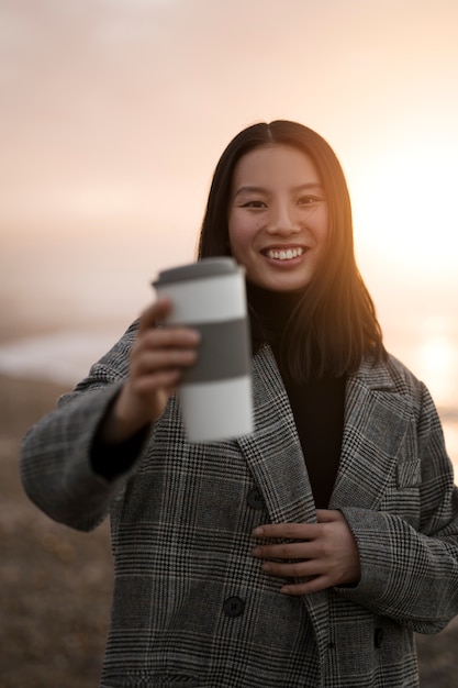 写真 コーヒーカップを保持しているフロントビュー女性