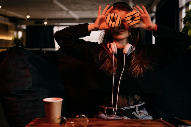 Photo front view woman holding donuts