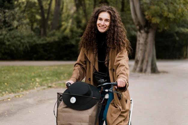 Фото Вид спереди женщина, держащая сумочку на велосипеде