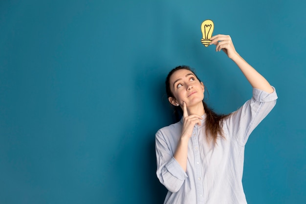 Photo front view woman holding idea light