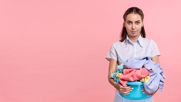 Photo front view woman holding a laundry basket