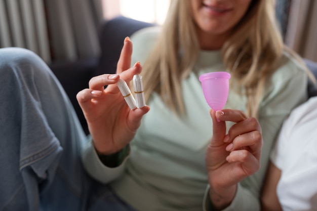 Photo front view woman holding menstrual products