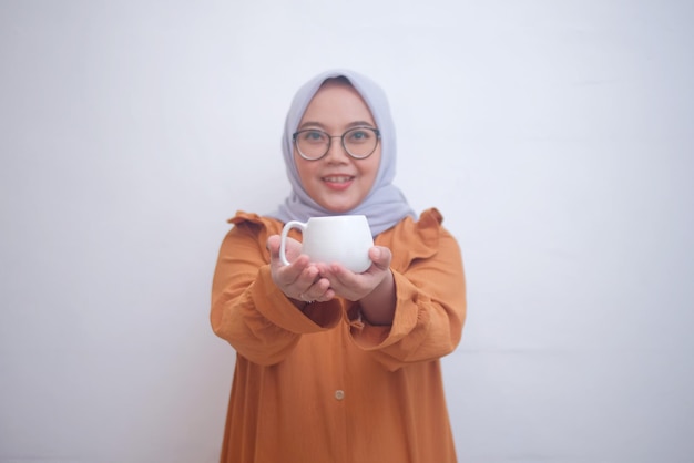 Front view of woman holding white cup