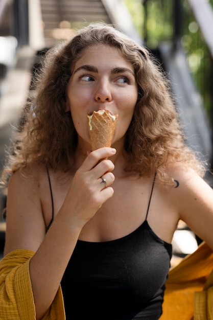 アイスクリームコーンをなめる正面図の女性
