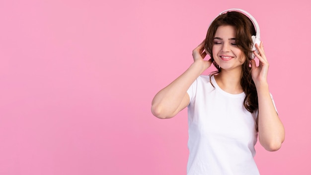 Front view of woman listening to music on headphones with copy space