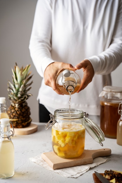 Foto donna di vista frontale che fa kombucha