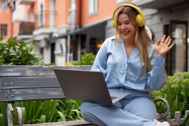 Front view woman making video calls with laptop