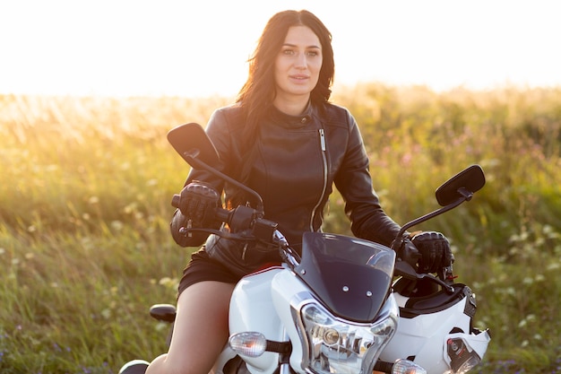 Front view of woman posing while riding her motorcycle