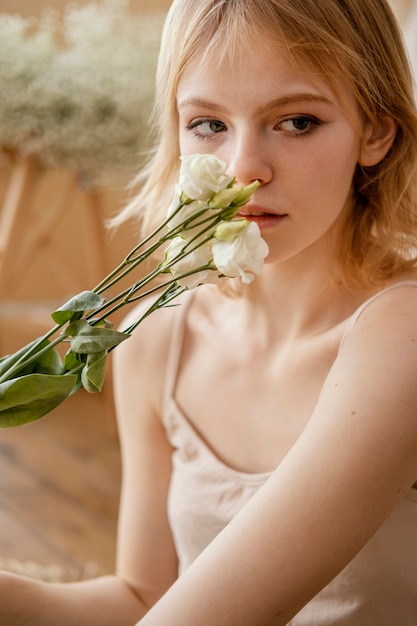 Front view of woman posing with delicate spring flowers