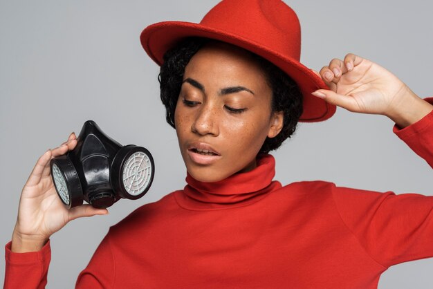 Front view of woman posing with mask and hat