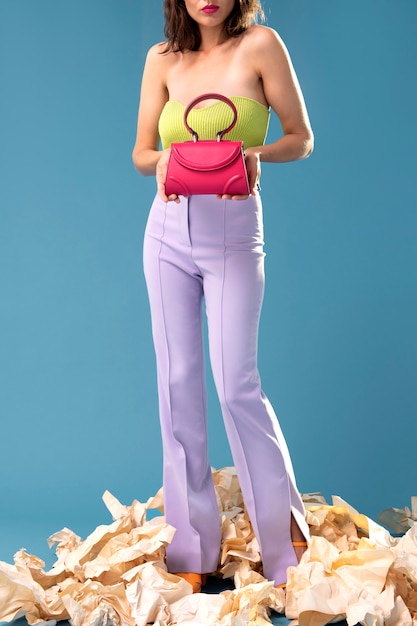 Foto donna di vista frontale che posa con la borsa rosa