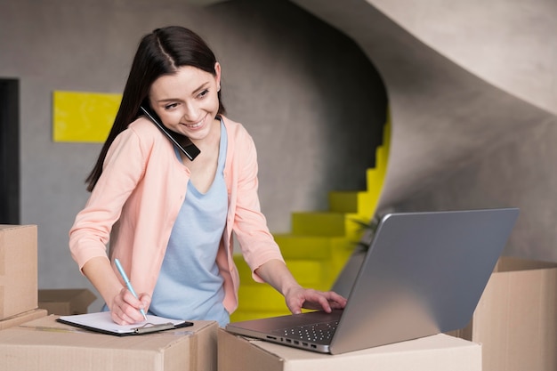 Foto vista frontale della donna che prepara le consegne da casa utilizzando il computer portatile