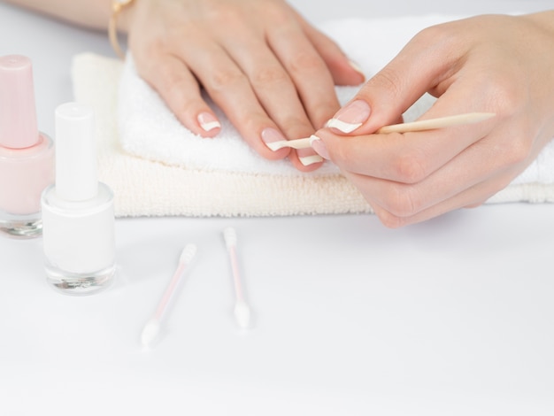 Photo front view woman's hands using manicure tools