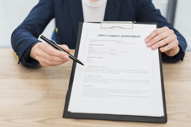 Front view of woman showing you where to sign new contract