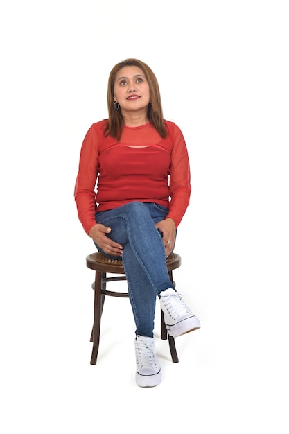 front view of a woman sitting on chair looking up and crosslegged on white background