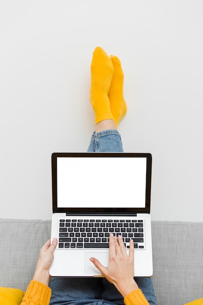 Photo front view of woman sitting upside down on sofa while working on laptop