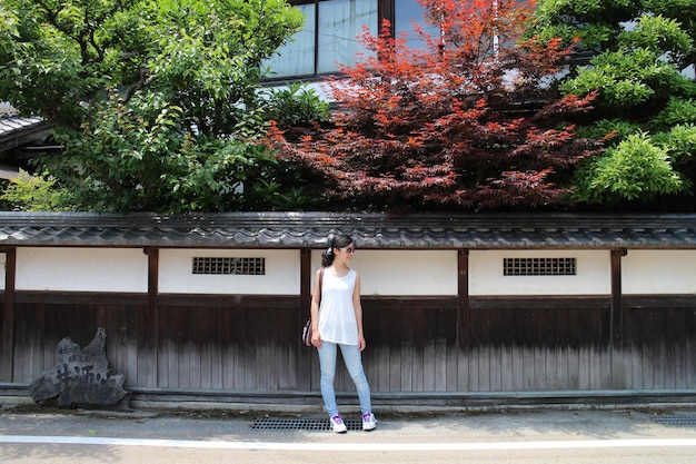 Front view of woman standing against building