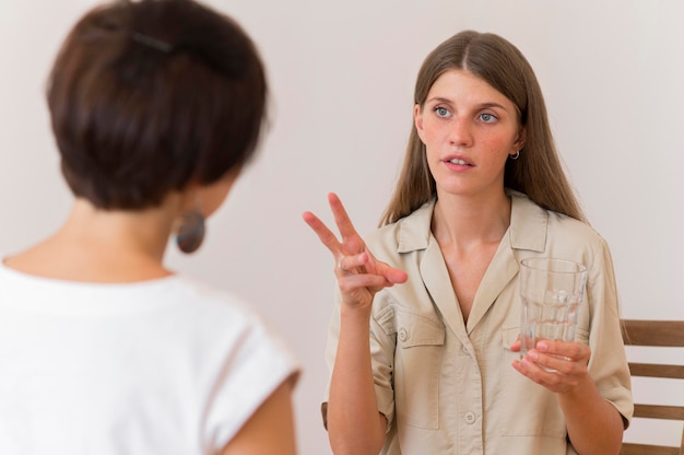 Front view of woman teaching sign language to another person