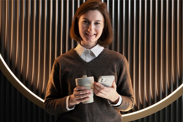 Photo front view woman with coffee and phone