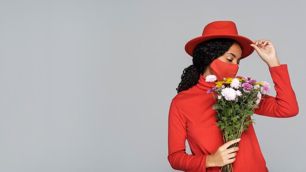 Photo front view of woman with mask and flowers