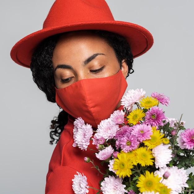 Vista frontale della donna con maschera e cappello