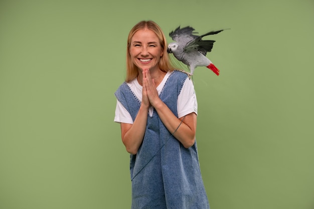 Photo front view woman with parrot in studio