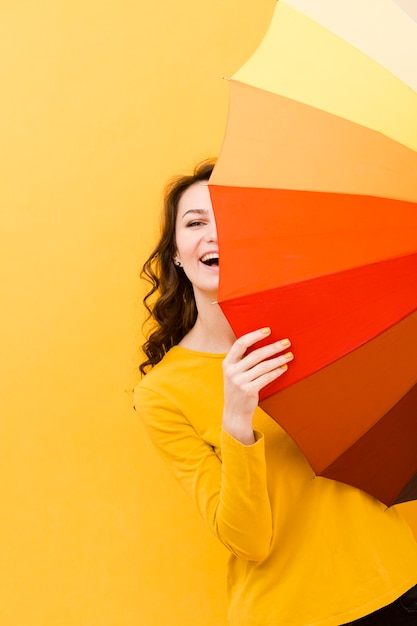 Vista frontale della donna con l'ombrello dell'arcobaleno