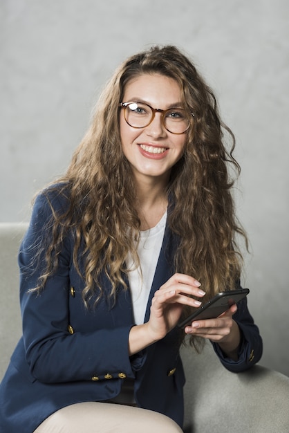 Photo front view of woman with smartphone waiting for her job interview