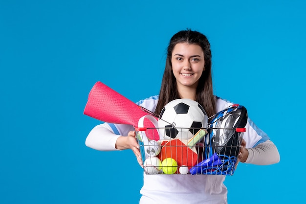 Front view young female after sport shopping on blue wall