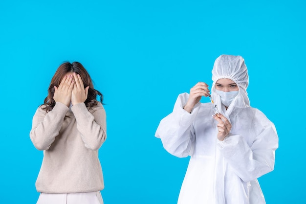 front view young female doctor in protective suit with patient on blue background science disease covid- pandemic health isolation medical