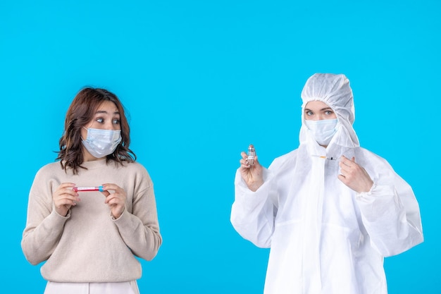 front view young female doctor in protective suit with patient on a blue background science disease medical virus covid- pandemic health isolation