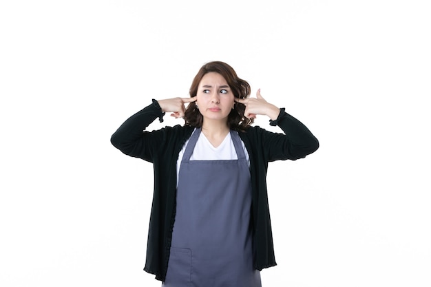 front view young female gardener stucking her ears on the white background woman color emotion garden tree green bush flower uniform