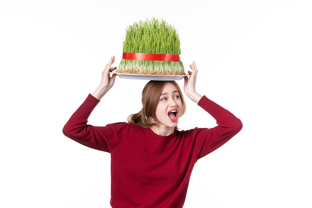 front view young female holding big green novruz semeni on her head on white background spring ethnic performers concept colours holiday family ethnicity