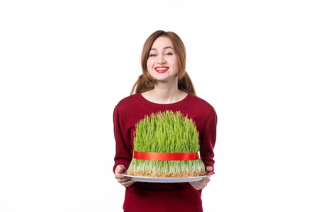 front view young female holding big green novruz semeni on white background spring ethnic performer ethnicity concept colours holiday family