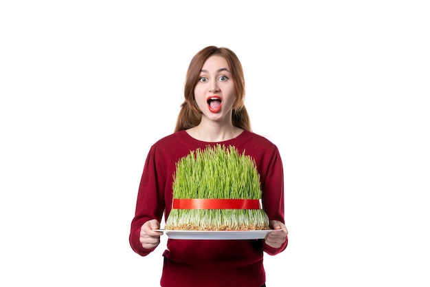 front view young female holding big green novruz semeni on white background spring ethnic performer ethnicity holiday concept family colours