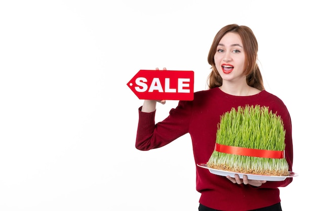 흰색 배경 개념 가족 쇼핑 수행자 민족 봄 색상에 큰 Novruz Semeni 및 판매 명판을 들고 전면 보기 젊은 여성