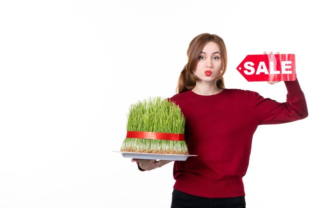 front view young female holding big novruz semeni and sale nameplate on white background colours performer ethnicity concept family shopping spring