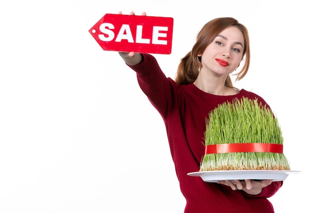 front view young female holding big novruz semeni and sale nameplate on white background colours performer ethnicity family shopping spring ethnic