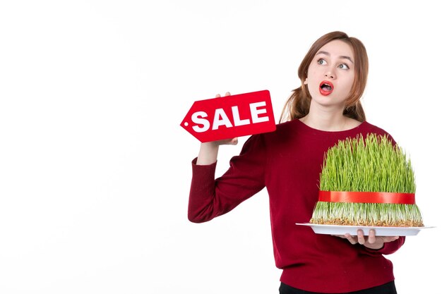 front view young female holding big novruz semeni and sale nameplate on white background concept ethnicity family shopping performer spring colours