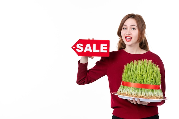 front view young female holding big novruz semeni and sale nameplate on white background concept family shopping performer ethnic spring colours