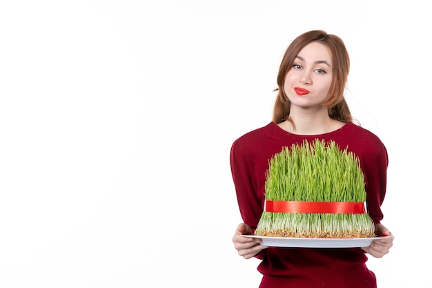 front view young female holding big novruz semeni on white background concept ethnicity family ethnic holidays spring performer colours