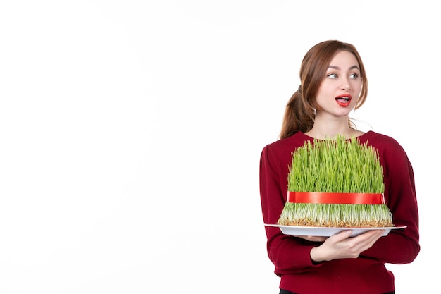 Photo front view young female holding big novruz semeni on white background ethnicity family ethnic holiday spring performer colours