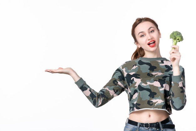 Front view young female holding little green broccoli on white background meal salad dish lunch human weight healthcare diet food health